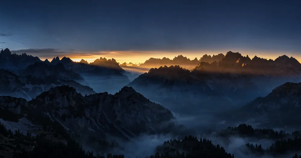 Dawn breaking over mountain peaks, the falaq splitting the darkness