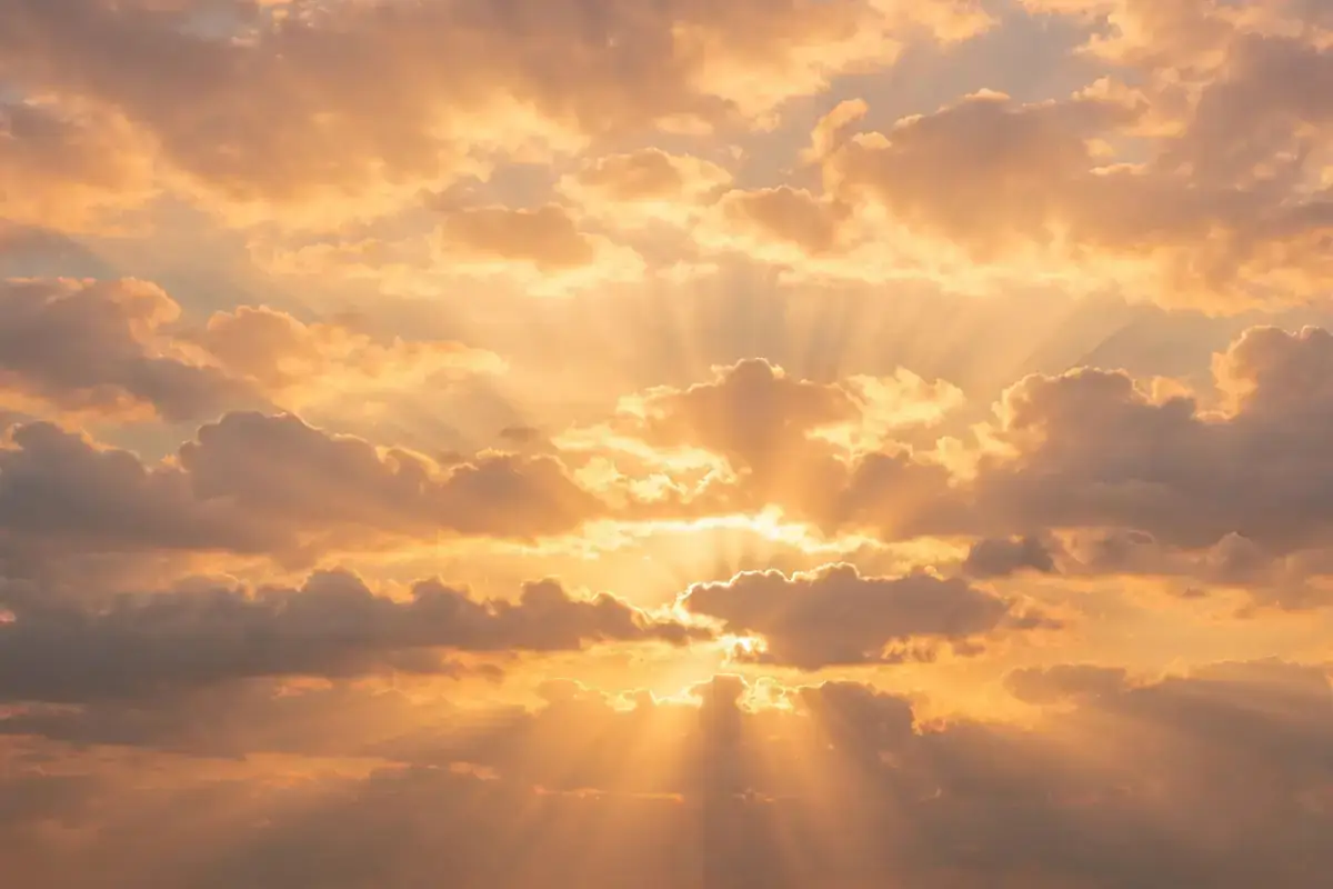 Open hands raised in supplication at sunset
