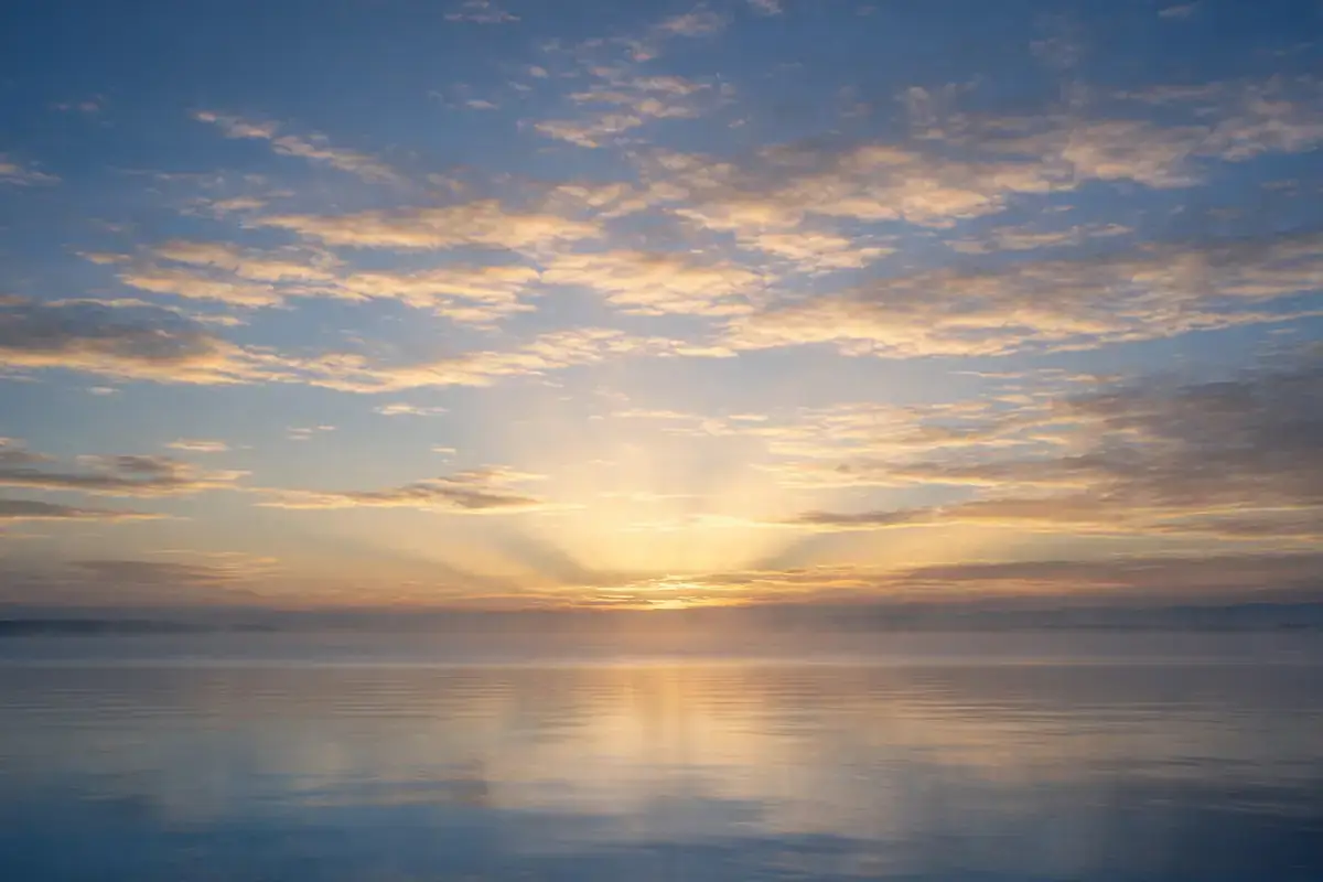First light of dawn breaking over a calm horizon