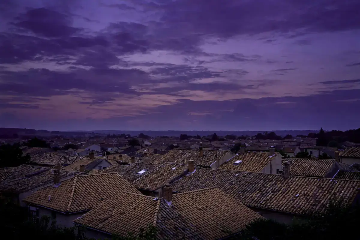 Dusk sky in deep purple over quiet rooftops